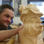 Sigi beim Schnitzen der Skulptur "Bauer mit Hut"